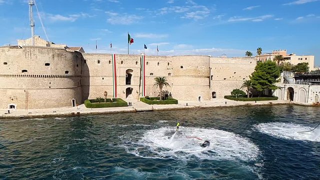 Flyboard Performance in the Taranto Canalboat in front the Aragonese Castle Decorated with Italian Flags, Souht of Italy. Slowmotion HD