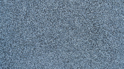 Old blue cement wall with bumps and pores. Dark textured background