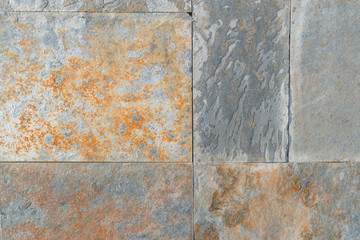 Wall of stone blocks damaged by rust and peeling with corrosion. Smooth seams. Artistic abstract...