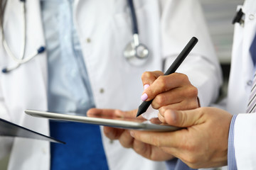 Female GP making electronic notes in tablet pc closeup