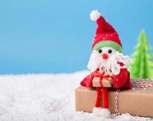 Decorating toy Santa holding happy holidays present in boxes