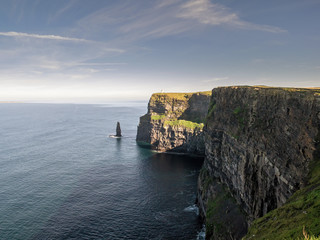 View on Cliff of Moher, Popular tourists destination in county Clare, Ireland. Warm sunny day, Blue sky and water.