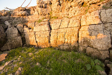 The curb erosion from storms. To indicate the layers of soil and rock.