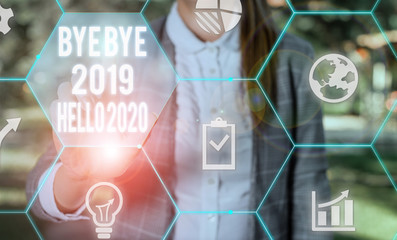 Writing note showing Bye Bye 2019 Hello 2020. Business concept for Starting new year Motivational message 2019 is over Female human wear formal work suit presenting smart device © A