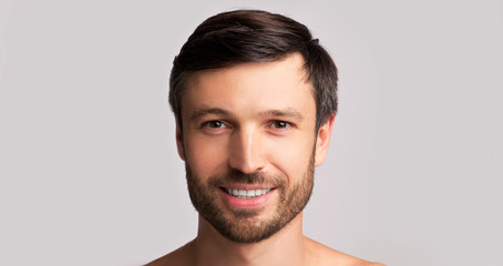 Fototapeta premium Smiling Middle-Aged Man Looking At Camera Over White Background, Panorama