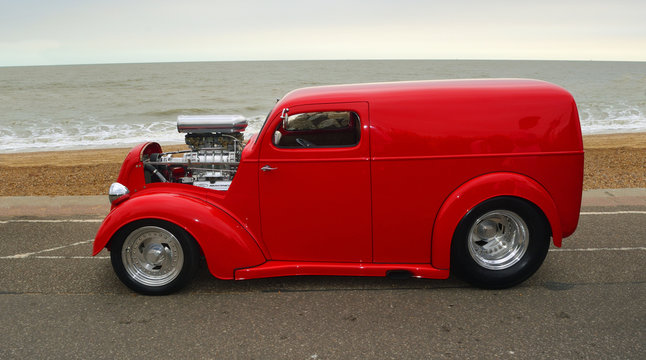  Customised Red Classic Hotrod parked on seafront promenade.