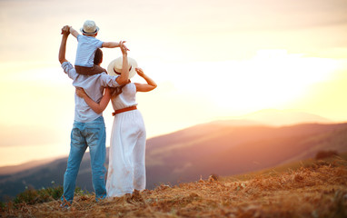 Happy family father of mother and child son  on nature at sunset