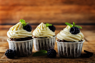 Chocolate banana cupcakes with cream cheese frosting and blackberries