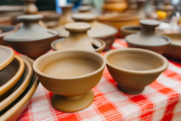 plates, cups, clay dishes close up. do-it-yourself ceramic dishes on local market. folk festival. 
