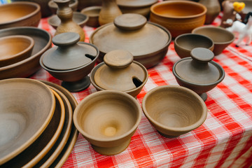 plates, cups, clay dishes close up. do-it-yourself ceramic dishes on local market. folk festival. 