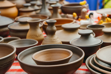 plates, cups, clay dishes close up. do-it-yourself ceramic dishes on local market. folk festival. 