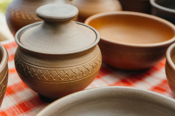 plates, cups, clay dishes close up. do-it-yourself ceramic dishes on local market. folk festival. 