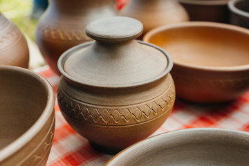 plates, cups, clay dishes close up. do-it-yourself ceramic dishes on local market. folk festival. 