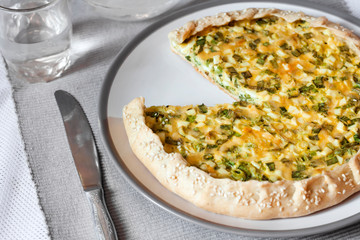 Tart with eggs and green onions on a plate