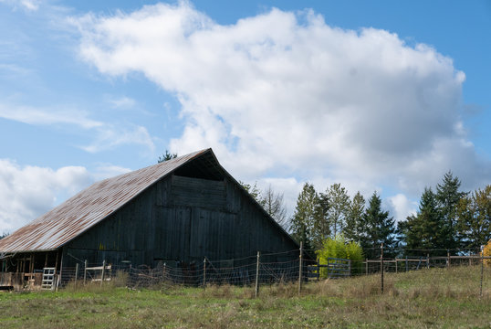 Old wooden barn against a cloudy blue sky