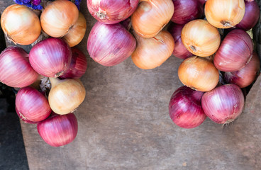 A colorful border of red and yellow onions on a gray background