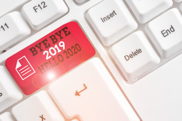 Word writing text Bye Bye 2019 Hello 2020. Business photo showcasing Starting new year Motivational message 2019 is over White pc keyboard with empty note paper above white background key copy space © A