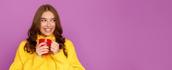 Young girl enjoying hot tea and looking at free space