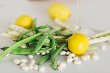 Green beans and lemon  in glass with white background