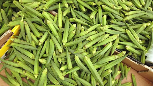 A pile of okra, abelmoschus esculentus, for sale on a market stall