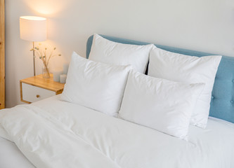 White pillows and duvet on the blue bed. White pillows, duvet and duvet case on a blue bed. White bed linen on a blue sofa. Bedroom with bed and bedding 