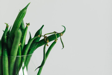 green beans in glass in front of white background