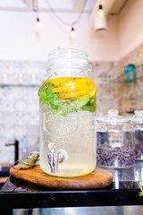 Obraz na płótnie Canvas Restaurant bartender pouring lemonade from fruit in glass jars