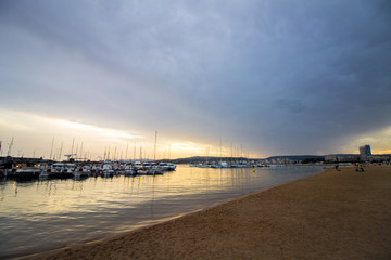 Dramatic Sunset Sky over the Beach of Palamós on the Spanish Costa Brava with Yachts in the Foreground