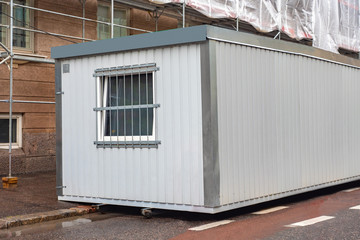 Temporary construction building. hange house outside. A small house for builders. The building is...