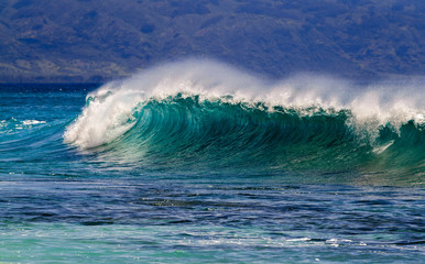 Breaking Ocean wave with Mountain background