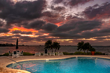 Swimming pool at sunset palm trees resort
