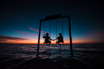 Couple contemplating an amazing sunset at Holbox Island in the Caribbean Ocean of Mexico