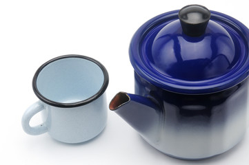 Vintage teapot in blue with a mug on a white background