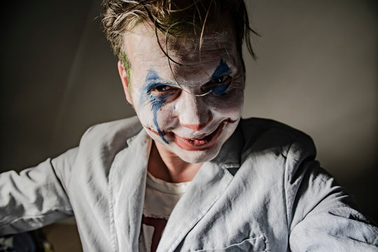 Halloween theme. The crazy joker face. Man in mime makeup cosplay