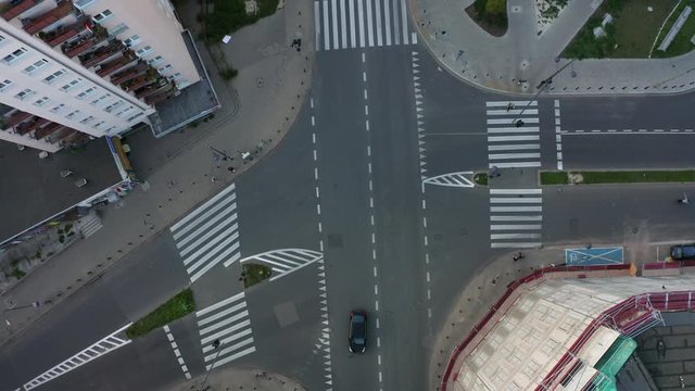 Drone shot on the street with intersections and cars. Car traffic on the road and people cross the street during the day in the center of Warsaw drone aerial view from above.  4K Shot.