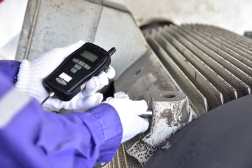Inspector using a Handheld Vibration Tester  for checking bearings and overall vibration of motor. Selective focus on inspection area. - obrazy, fototapety, plakaty