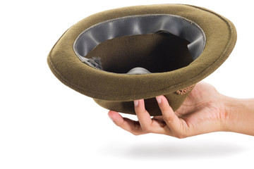 The human's hand is holding the green fedora hat isolated on white background with clipping path.