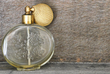 Antique glass perfume bottle to the side, with wooden background