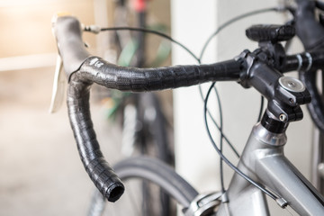 Selective focus of bicycle handle on  blurred background with sunlight