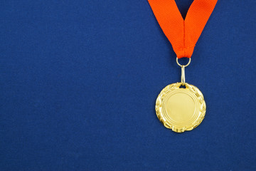 Gold medal with red ribbon on blue background