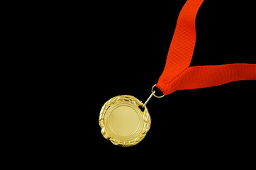 Gold medal with red ribbon isolated on black background