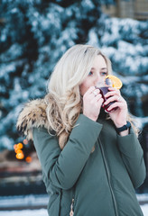 Beautiful smiling woman with mulled wine outdoor.