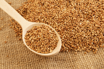 Buckwheat on burlap sack with wooden spoon