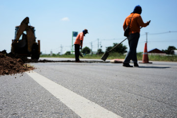 Heavy equipment digging to repair the damaged road (blurred pictures)