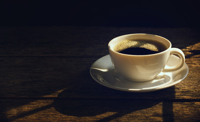 Closeup black coffee in white cup with sunlight in the morning