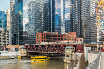 Chicago River walk with Yacht running and traing running over the rail track, illinois, USA....