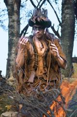 young shaman conducts ritual about burning a fire