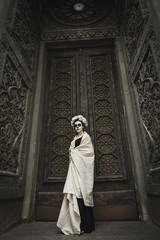 Calavera Catrina in the dark. Fashion model with sugar skull makeup. Dia de los muertos. Day of The Dead. Halloween.