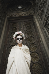 Fototapeta premium Calavera Catrina in the dark. Fashion model with sugar skull makeup. Dia de los muertos. Day of The Dead. Halloween.