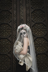 Calavera Catrina in the dark. Fashion model with sugar skull makeup. Dia de los muertos. Day of The Dead. Halloween.